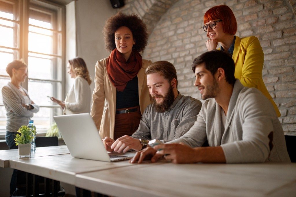 group of people working in front of a laptop