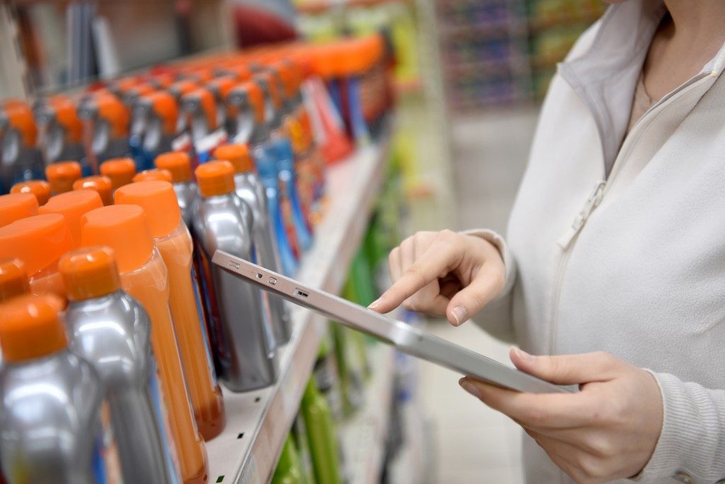 Woman merchandiser checking products available with digital tablet