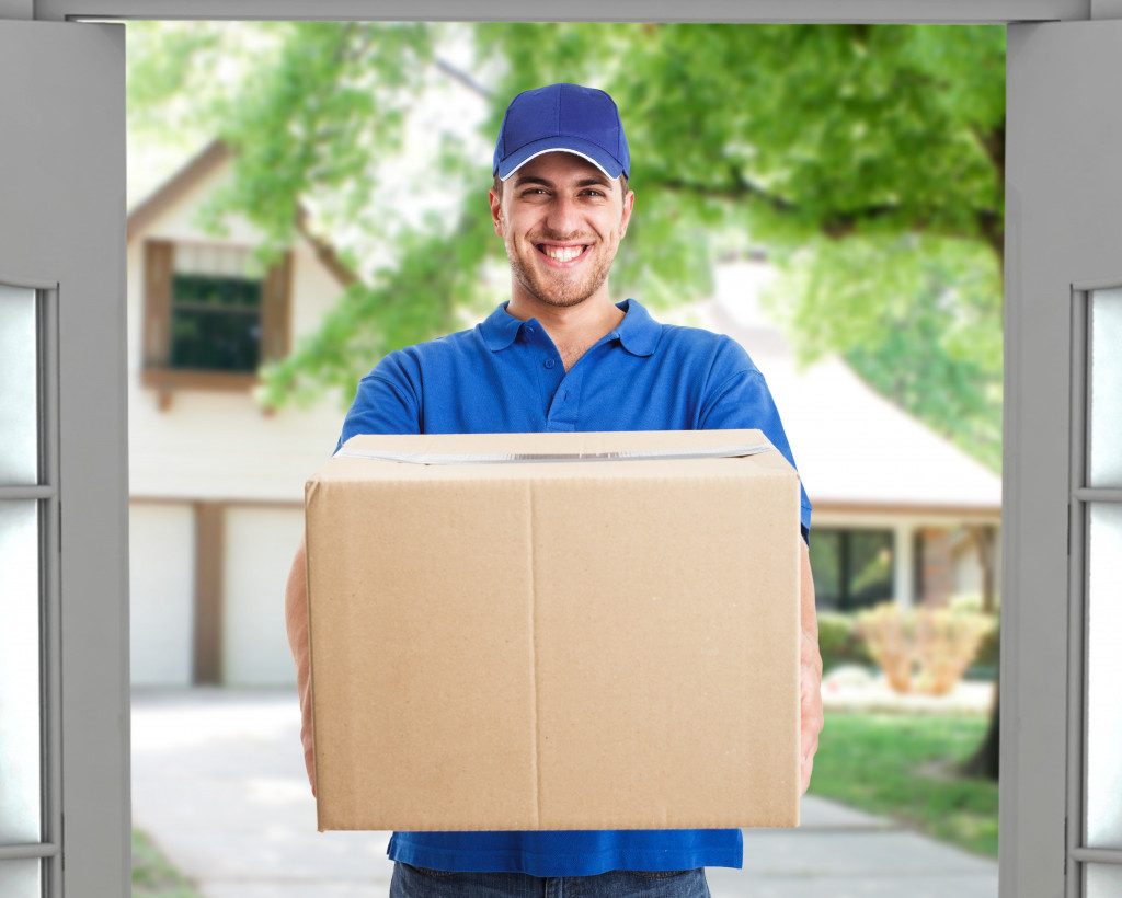 delivery guy in blue shirt and cap delivering a customer's package