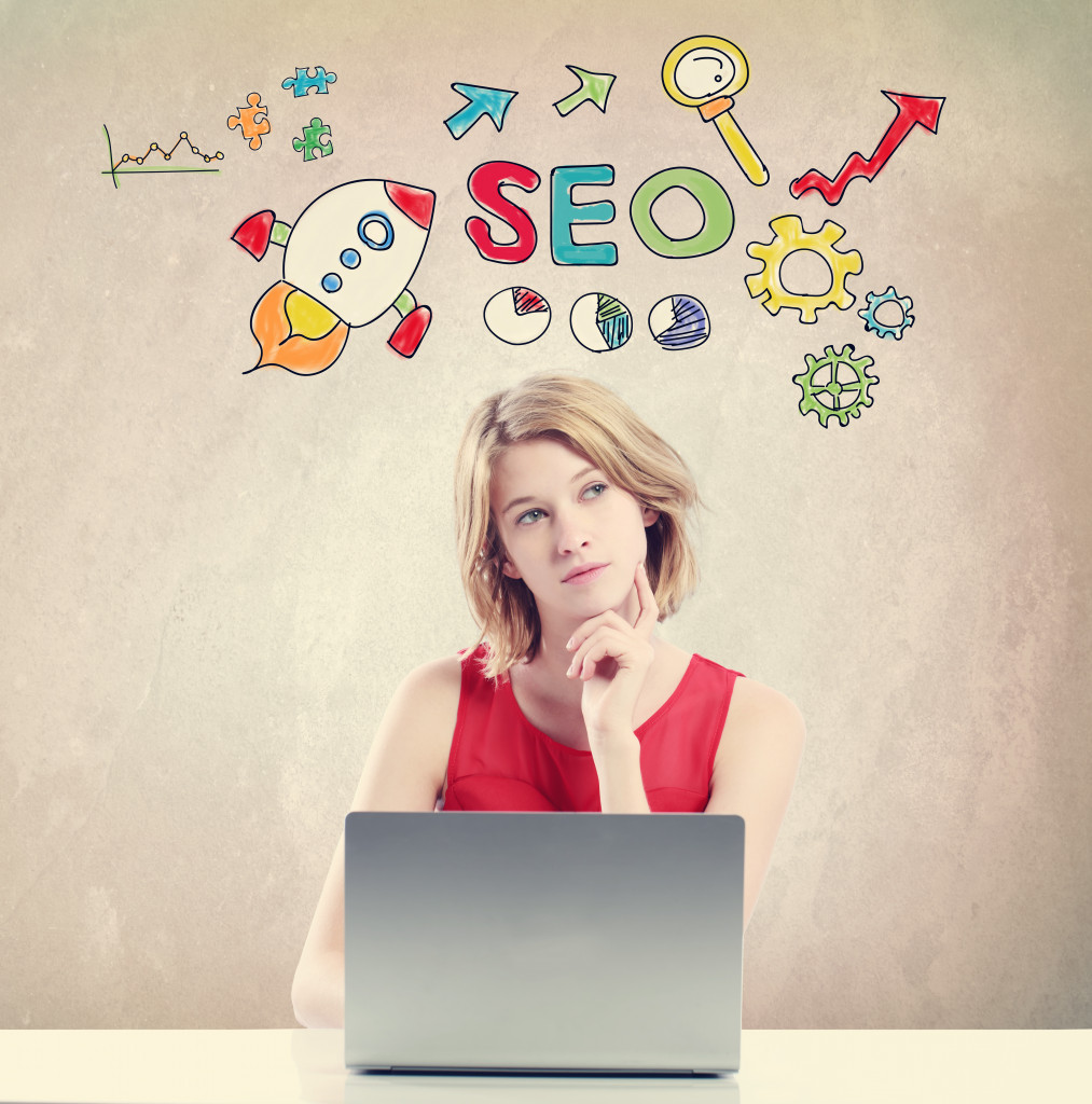 A woman thinking of SEO while working on a laptop
