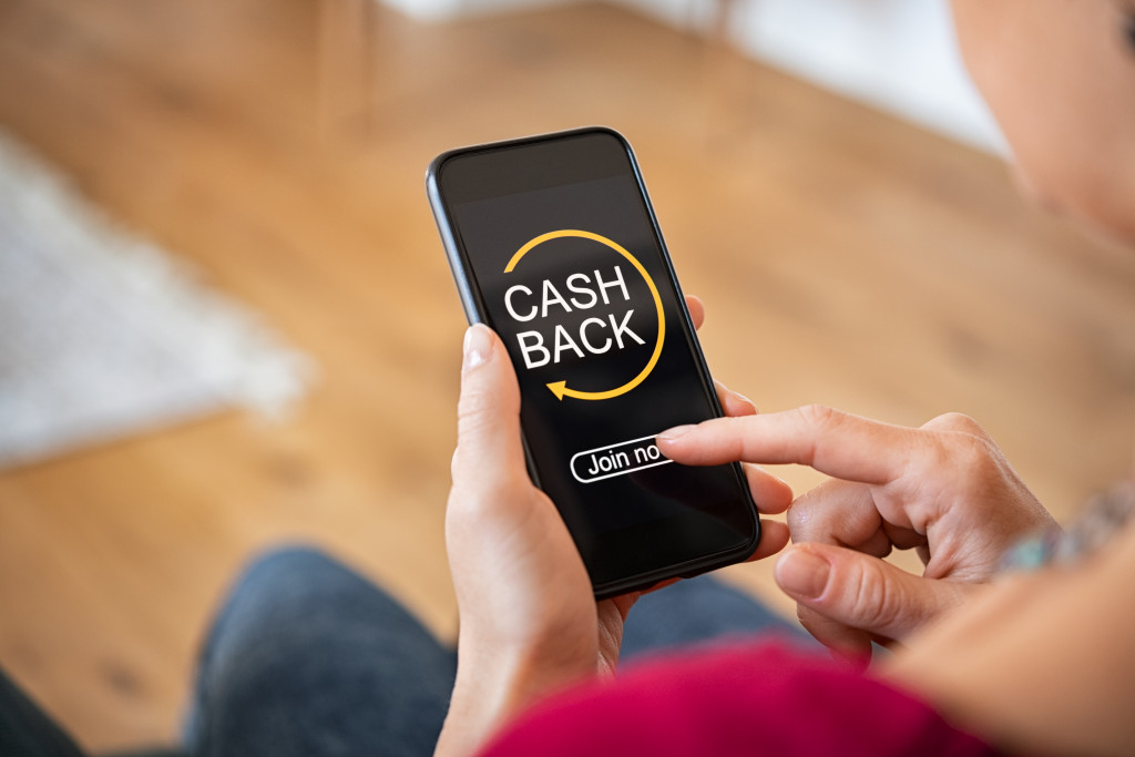 woman using cash back app on her phone